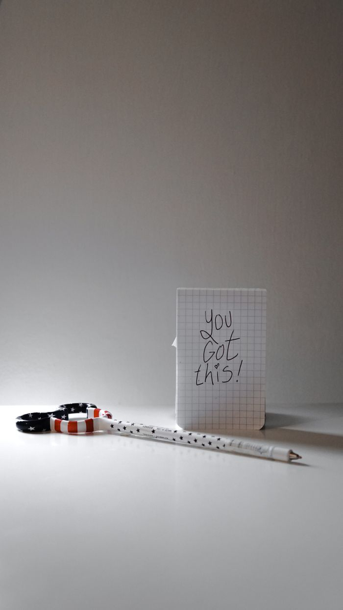 About Inspirational message on paper with a pen and colorful scissors for creativity boost.